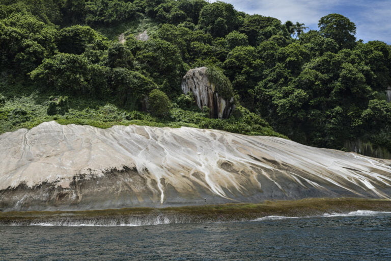 Porção do costão rochoso da Ilha Jorge Grego, situada ao largo da Ilha Grande. Na pedra, as marcas brancas das fezes de aves marinhas espalhadas pela chuvas. © Luciano Candisani